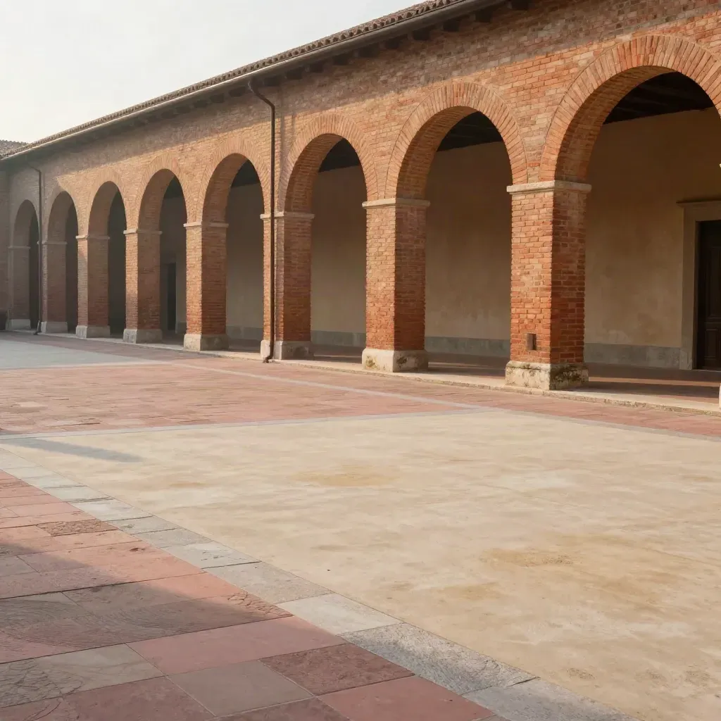 Portici in laterizio dell'Emilia-Romagna al tramonto, con pavimentazione rosata e luce morbida.